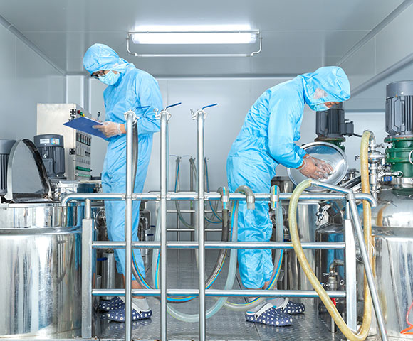 Workers wearing standard production hygiene clothing is operating emulsifying equipment