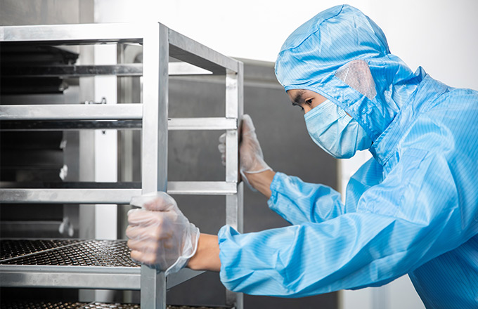 A worker is opening the disinfection cabinet and taking out the sterilized bottles