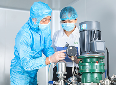 A worker is assisting third party staff in inspection of emulsifying machines